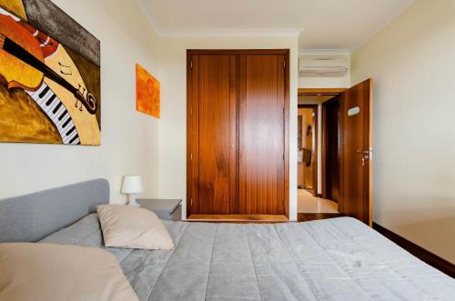 a bedroom with a bed and a wooden door at To Be Apartments in Bobadela