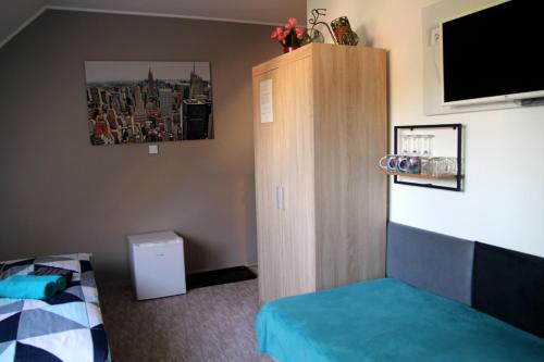 a bedroom with a bed and a wooden cabinet at APARTMÁNY PIETRO in Oravský Podzámok