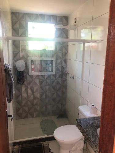 a bathroom with a shower with a toilet and a sink at House DayDrigo in Búzios