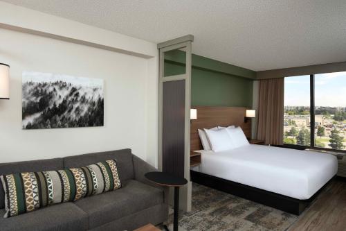 um quarto de hotel com uma cama e um sofá em Hyatt Place Denver-South/Park Meadows em Lone Tree
