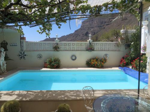 a swimming pool in a patio with a mountain in the background at Finca Cortez Apartment 4 in San Bartolomé de Tirajana