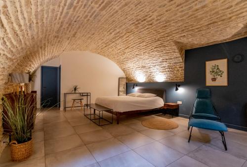 a bedroom with a bed and a stone ceiling at La chouette d'or in Dijon