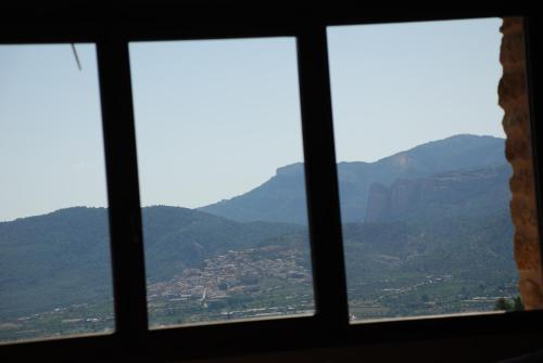 a view from a window of mountains at Masia de la Serra de la Cogulla in Peñarroya de Tastavins