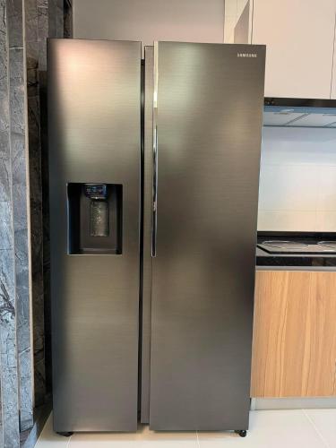 a stainless steel refrigerator with a clock on it at Sri Indah condominium in Sandakan