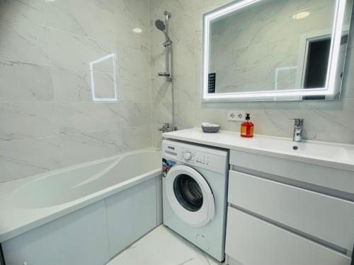 La salle de bains est pourvue d'un lave-linge et d'un lavabo. dans l'établissement На Куліша 3, сучасні апартаменти біля оперного, à Lviv