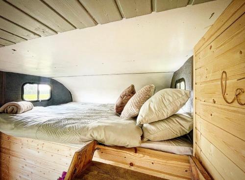 a bed in a wooden room with pillows on it at North Yorkshire Horse Box in York