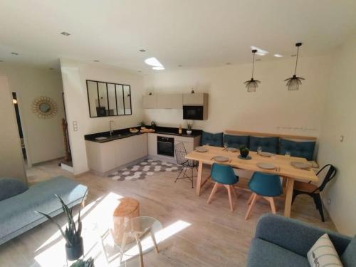 孔卡尔诺La Maison de Tante Yvonne - Gîte de Kerblaise的一间厨房和一间带桌椅的客厅