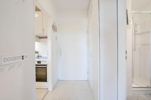 eine Küche mit weißen Wänden und einer offenen Tür in der Unterkunft Appartementanlage Kammerweg 5-5b Kleinaberfein in Scharbeutz