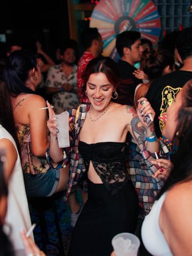 una mujer bailando entre la multitud en una fiesta en The Point Miraflores - Party Hostel en Lima