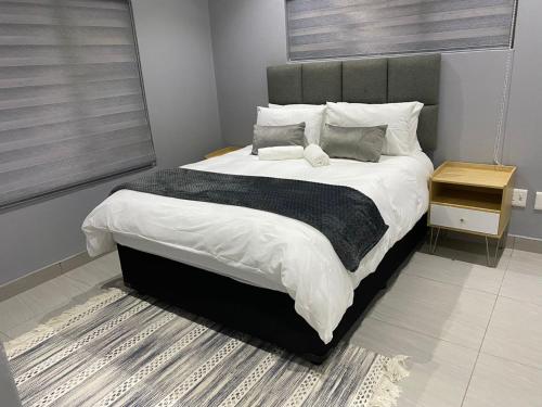 a bedroom with a large bed with white sheets and pillows at Ongwe Complex - Holiday Apartment in Swakopmund