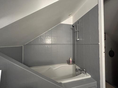 a white bath tub in a bathroom with a staircase at CHAMBRE PRIVÉE dans une maison in Argenteuil