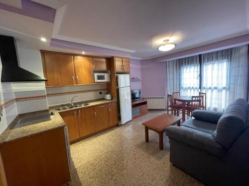 a kitchen and living room with a couch and a table at Apartamentos Villa de Ainsa in Aínsa