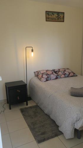 - une chambre avec un lit, une lampe et une table de chevet dans l'établissement Quartier Sainte Marthe Paris 10, à Paris