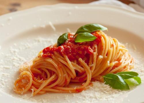 a plate of spaghetti with sauce and basil on it at Hotel JMS Holiday Allgäu in Oberreute