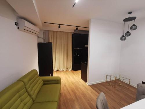 ein Wohnzimmer mit einem grünen Sofa und Holzböden in der Unterkunft Tina Apartment N64 in Agaraki