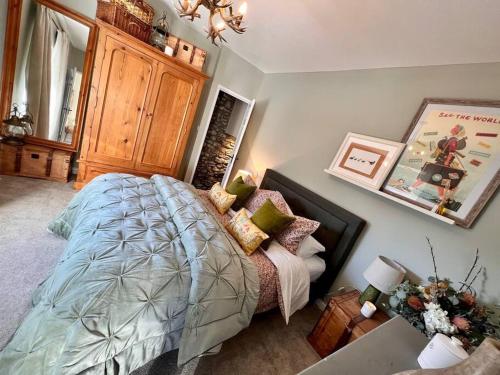 a bedroom with a bed and a wooden cabinet at 4 - BBQ Hut - Log Burner - Valley Views in Pont Sticill