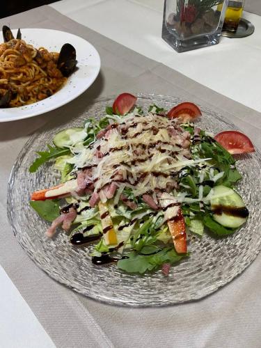a salad on a glass plate on a table at Hotel JMS Holiday Allgäu in Oberreute