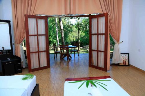 a room with a door open to a room with a table at River Edge Yala in Tissamaharama