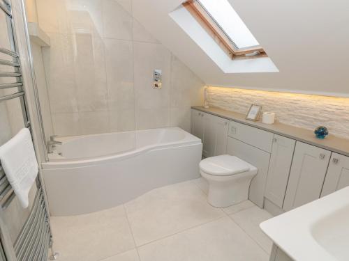 a bathroom with a tub and a toilet and a sink at Raleigh House in Salcombe