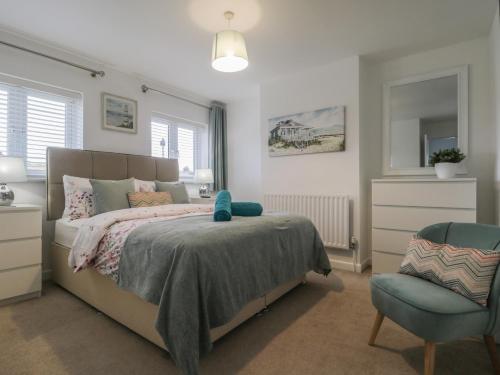 a bedroom with a bed and a chair at Holly Tree House in Herne Bay