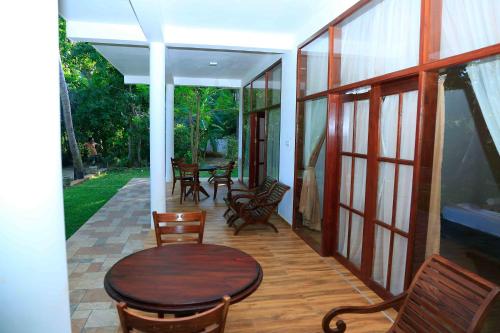 a patio with a wooden table and chairs and a table and chairsktop at River Edge Yala in Tissamaharama