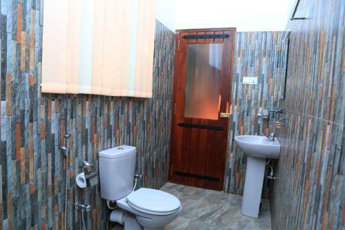 a bathroom with a toilet and a sink at River Edge Yala in Tissamaharama