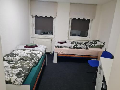 2 Betten in einem Zimmer mit 2 Fenstern in der Unterkunft Monteur- und Ferienwohnung Siegen Miller in Siegen