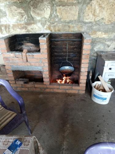 a brick oven with a pot over a fire at Kuca za odmor Marina Jelenkovic in Knjazevac.
