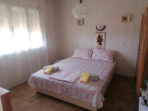 um pequeno quarto com uma cama rosa e almofadas amarelas em Kuca za odmor Marina Jelenkovic em Knjazevac.