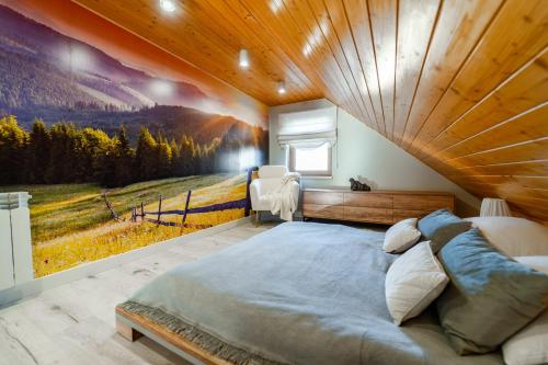 a bedroom with a large bed and a painting on the wall at Domek Rychwałdówka blisko jeziora Żywieckiego in Rychwałd