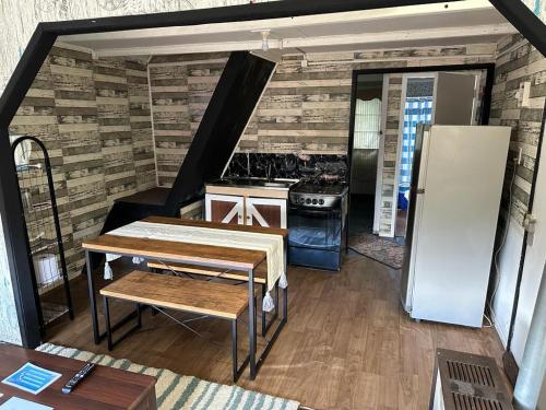 a kitchen with a refrigerator and a table in a room at Cabaña Cony in Puerto Natales