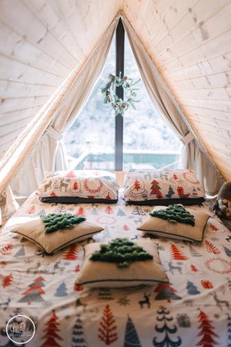 un lit avec quatre oreillers dans une chambre avec une fenêtre dans l'établissement SouL EsCaPe, à Bălan
