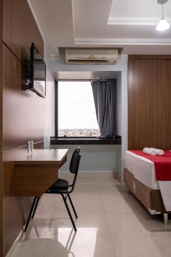 a bedroom with a bed and a desk and a deskablish at Rede Andrade Amazônia in Manaus