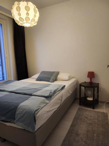 a bedroom with a bed and a table with a lamp at Easy stay in Tampere