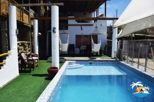 una piscina en un patio con sillas y una casa en Hospedaje Casa Mercedes Beach, en Canoas de Punta Sal