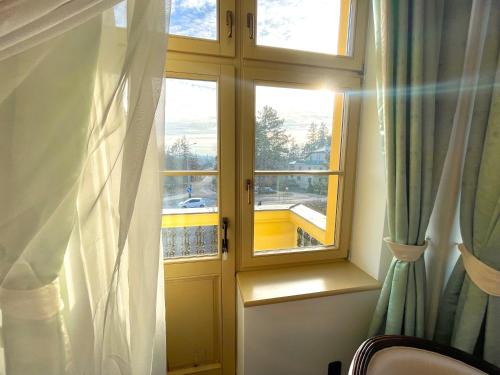 a room with two windows and a curtain at Palace Inn in Jíloviště