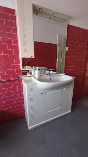 bagno con lavandino bianco e parete di mattoni rossi di Savena House a Bologna