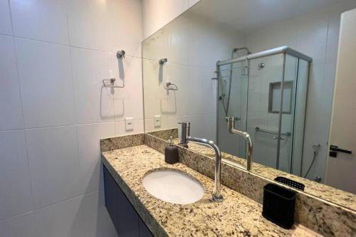 a bathroom with a sink and a glass shower at Lar da Abundância: Apartamento 3 Quartos no Leblon in Rio de Janeiro