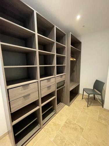 a closet with wooden shelves and a chair in a room at La Remise-Gîte de charme 7 personnes avec jacuzzi in Saint-André-de-Sangonis