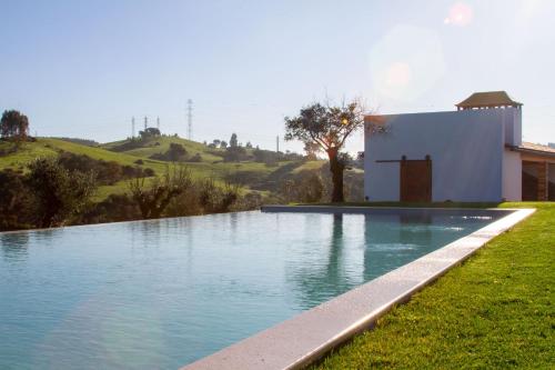 a swimming pool in the grass next to a house at Quinta de Matrena in Macieiros