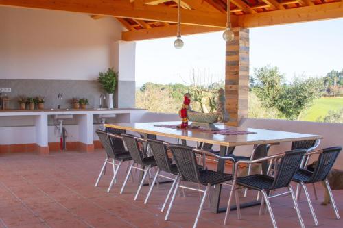 a patio with a table and chairs and a kitchen at Quinta de Matrena in Macieiros