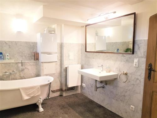 y baño con bañera, lavamanos y bañera. en Deluxe-Appartement-70m2-mit-Fruehstueck-Gruppenunterkuenfte-im-Oberharz en Sankt Andreasberg