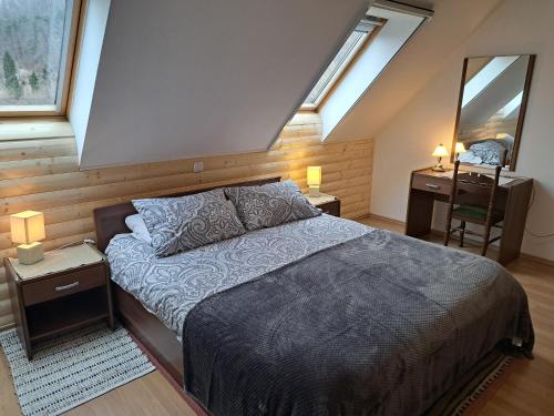 a bedroom with a bed and two tables and two windows at Apartment Erika in Fužine
