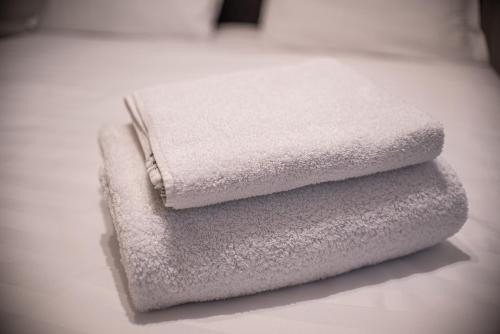 three towels stacked on top of each other in a bathroom at Maria's Premium Suite in Baia Mare