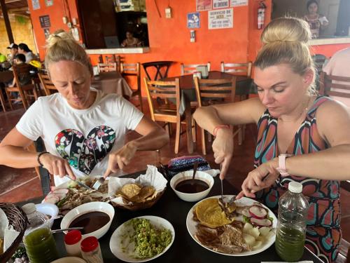 two women sitting at a table eating food at La casita maya, Valladolid in Valladolid