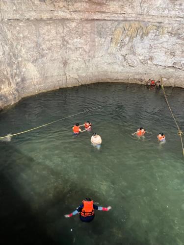 a group of people in the water in a cave at La casita maya, Valladolid in Valladolid