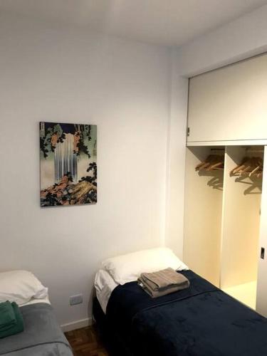 um quarto com uma cama e uma fotografia na parede em 2 ambientes, Rosedal de Palermo y embajada EEUU em Buenos Aires