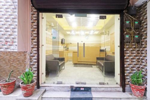 a glass door with two plants in a room at Hotel The Nines - Dashrathpuri Metro in New Delhi