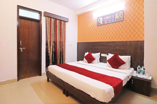 a bedroom with a large bed with red pillows at Hotel The Nines - Dashrathpuri Metro in New Delhi