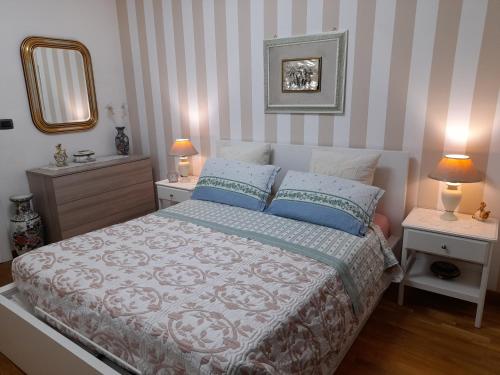 una camera da letto con un letto con due comodini e uno specchio di INALPI ARENA ex Pala Alpitour-STADIO OLIMPICO - Luxury Apartment Virgilio - Santa Rita a Torino
